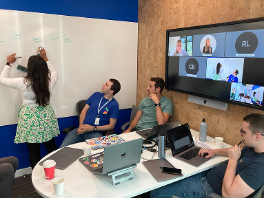 Karishma at a whiteboard with her product and engineering leads, remote colleagues on screen