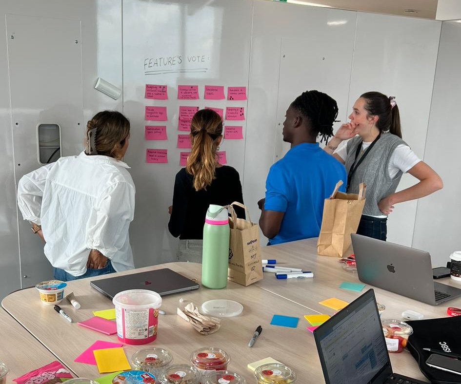 Team voting on features at a wall of sticky notes